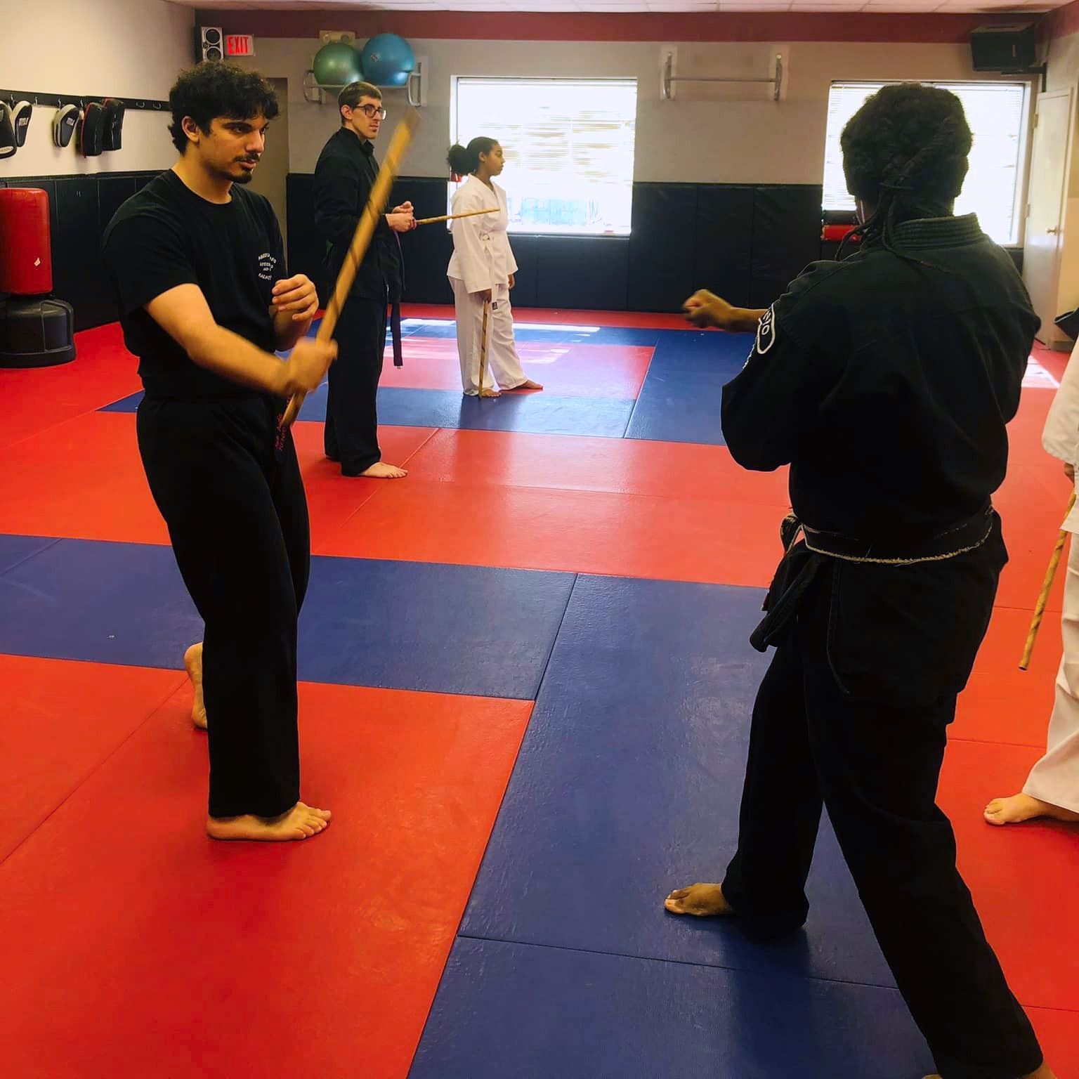 a group of people are practicing martial arts in a gym