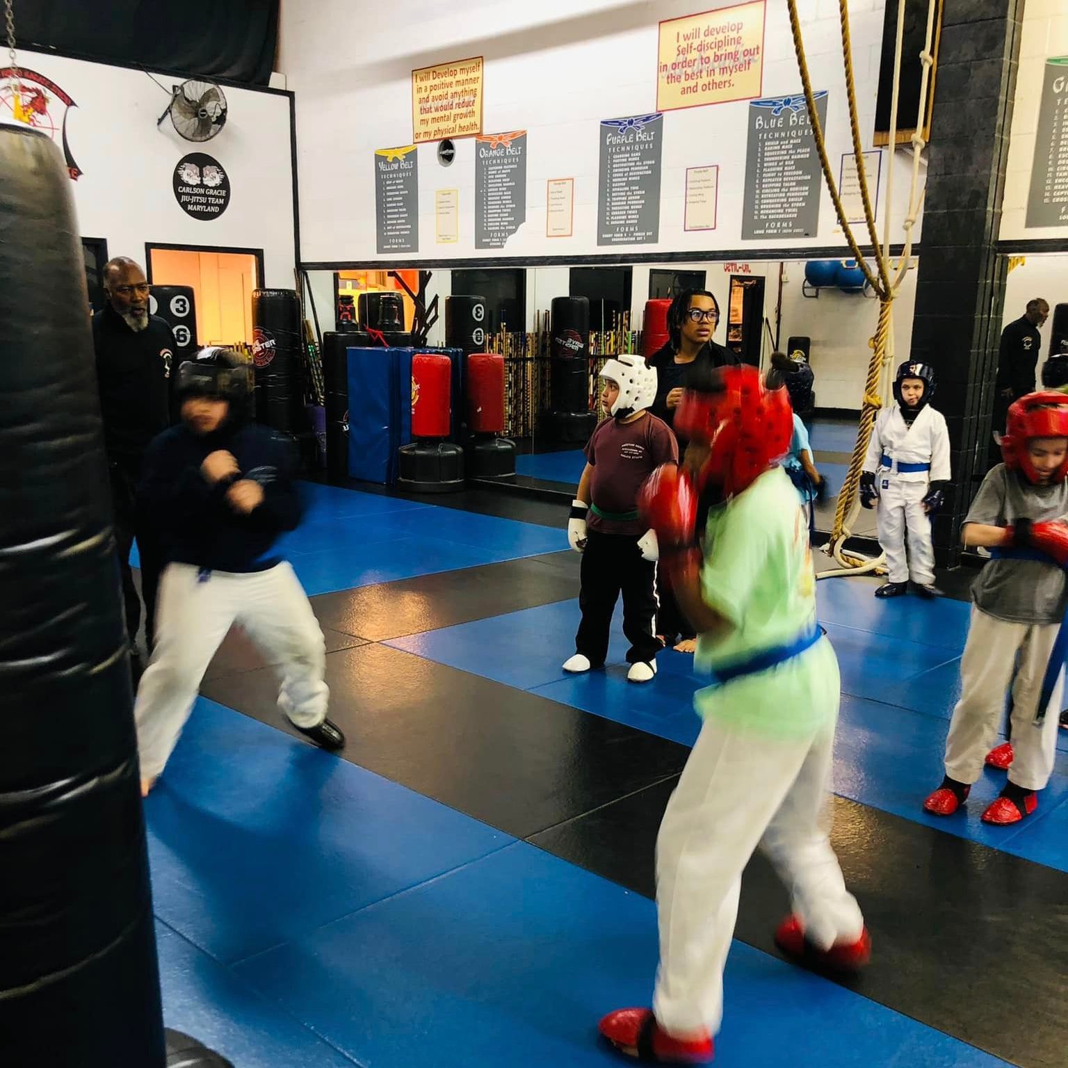 a group of kids are practicing martial arts in a gym