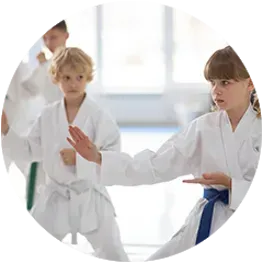 a group of children are practicing karate in a gym .