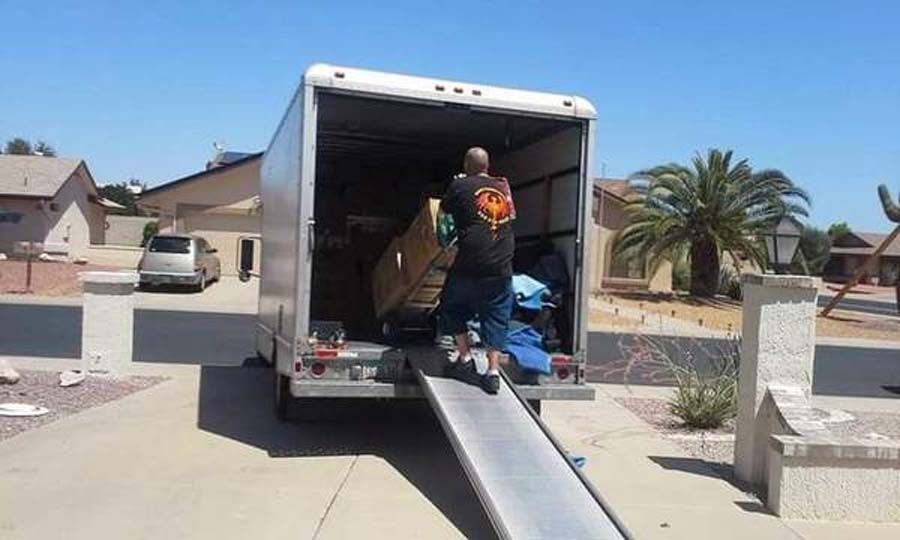 a man is loading a large box into a moving truck .