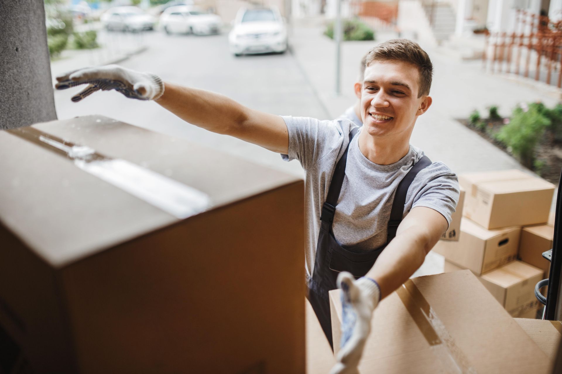 a man is holding a cardboard box in his hand and smiling .