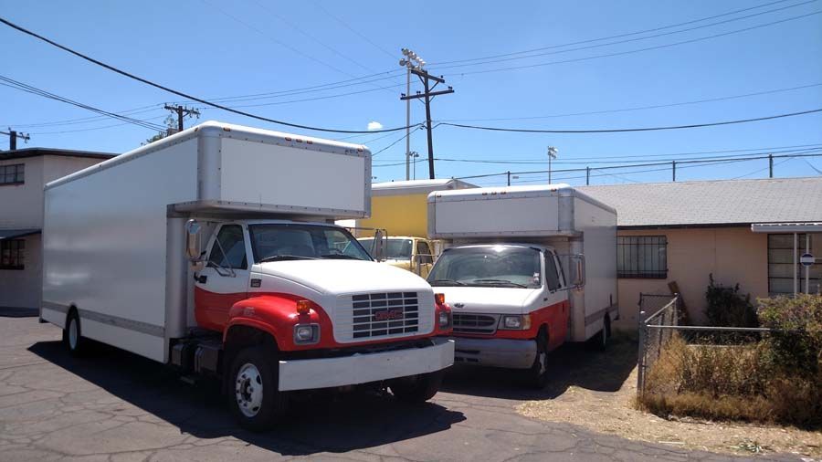 two moving trucks are parked in front of a house