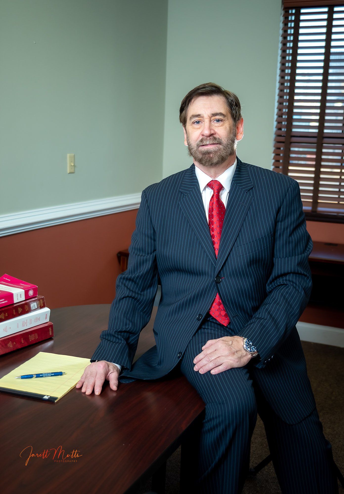 A man in a suit and tie is sitting at a desk.