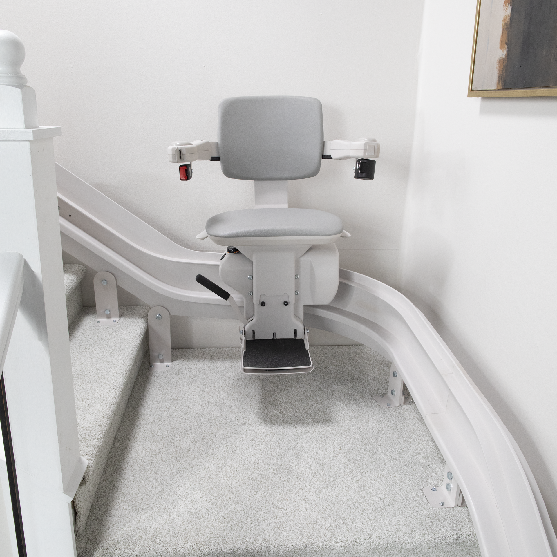 A white chair is sitting on the stairs in a living room