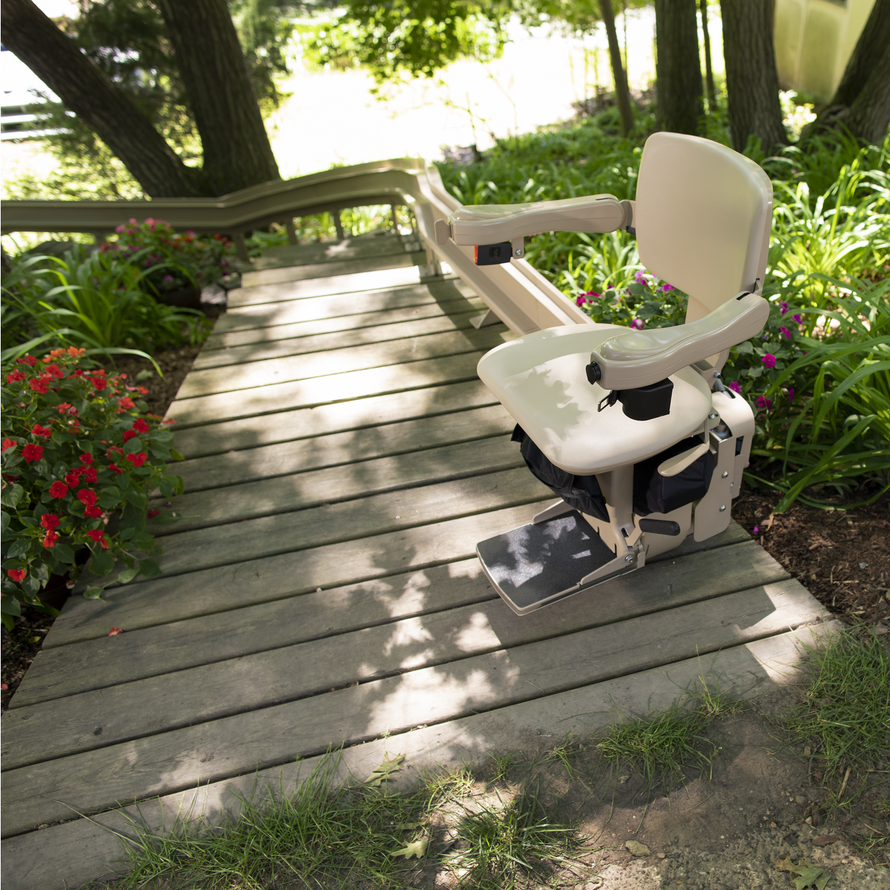 A stair lift with a gray seat and a wooden railing