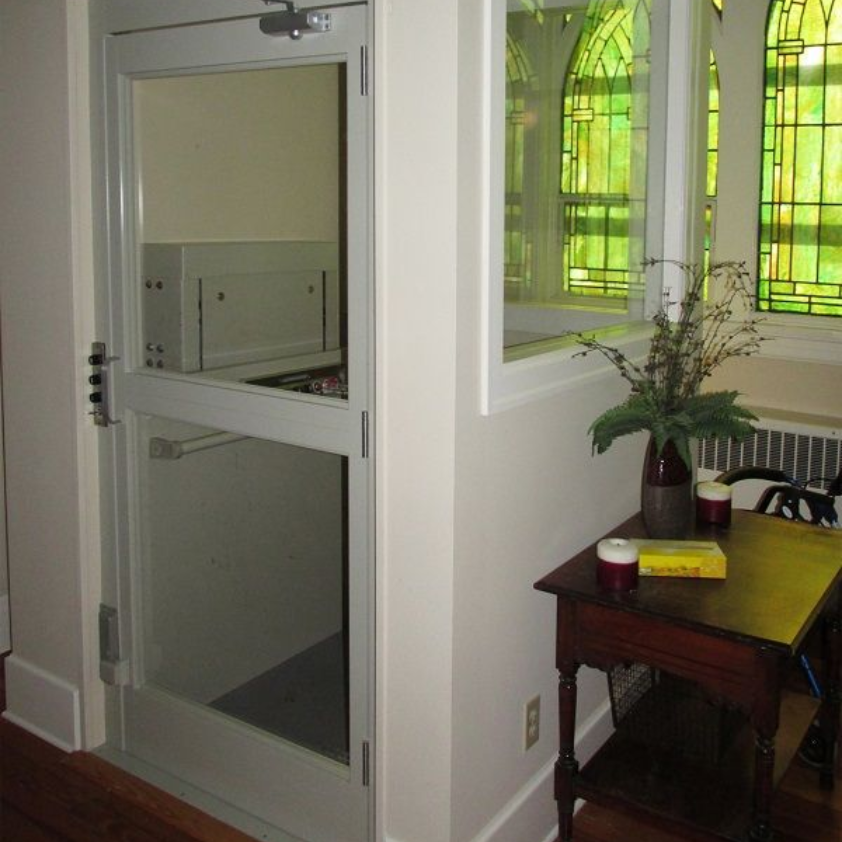 A stair lift with a gray seat and a wooden railing