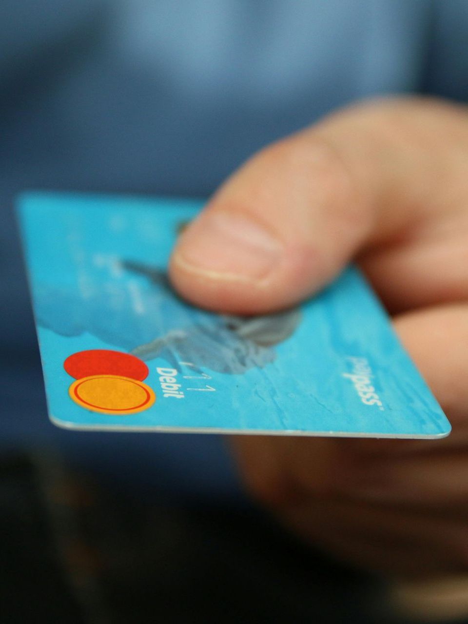A person is holding a credit card in their hand.