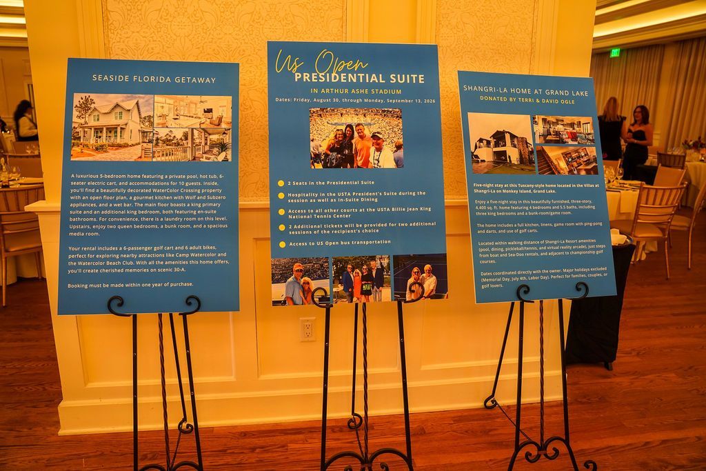 Three blue event posters on black stands in a wood-paneled lobby