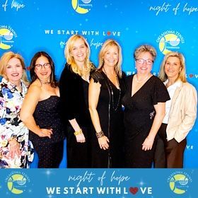 Six women pose in front of a blue “Night of Hope” event backdrop.