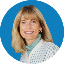 Head-and-shoulders portrait of a smiling woman against a blue background