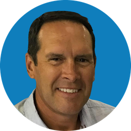 Headshot of a smiling man against a blue background