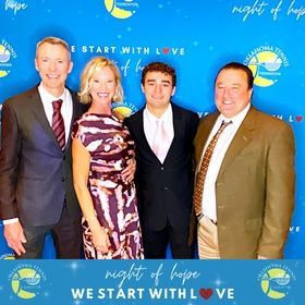 Four people posing at a Night of Hope event step-and-repeat backdrop.