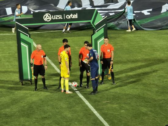 I calciatori e gli arbitri si posizionano a centrocampo per il sorteggio prima del calcio d'inizio.
