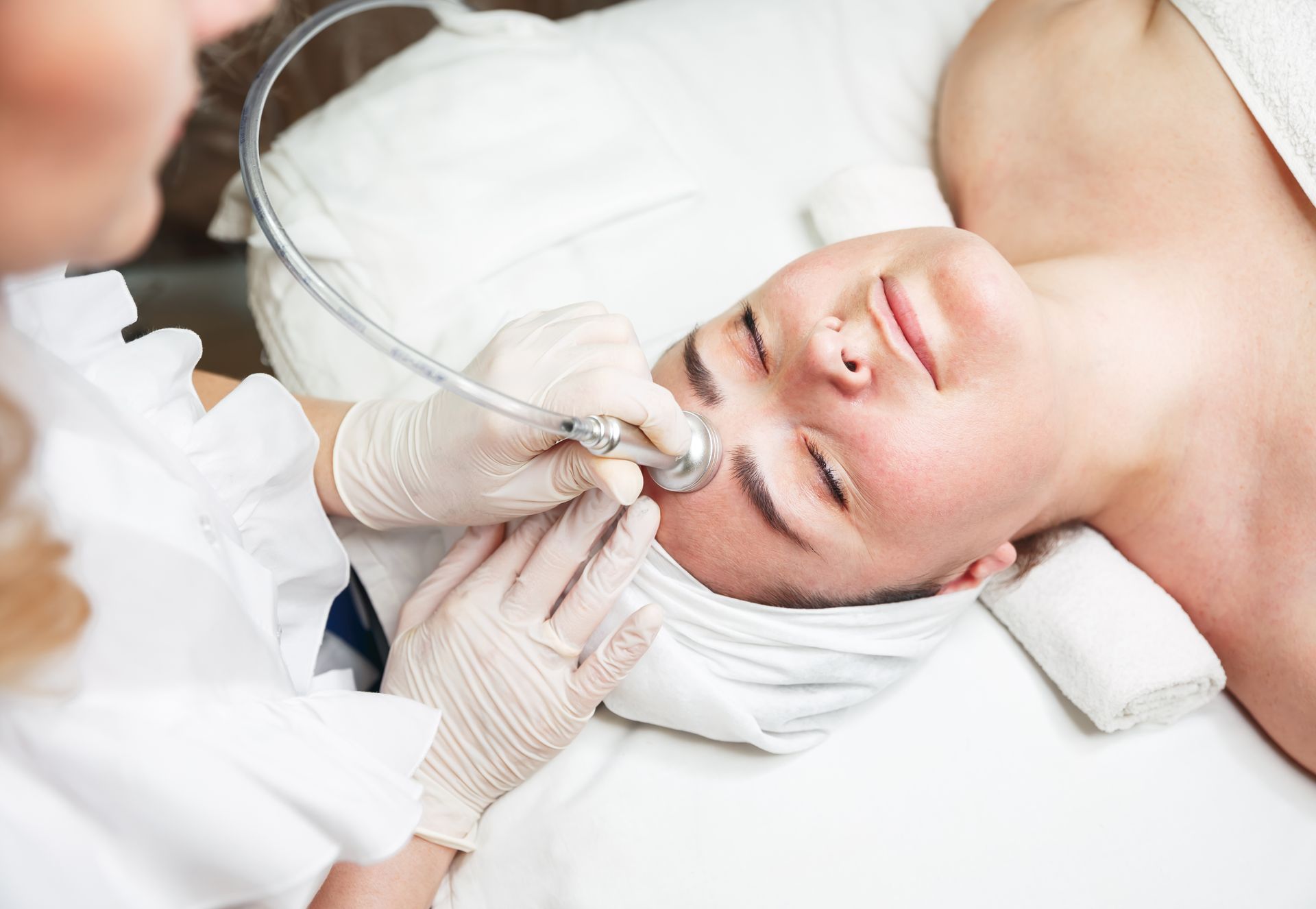 Aesthetician performing microdermabrasion facial on a patient at Clinica Santa Maria Wellness Med Spa in Brownsville, TX.
