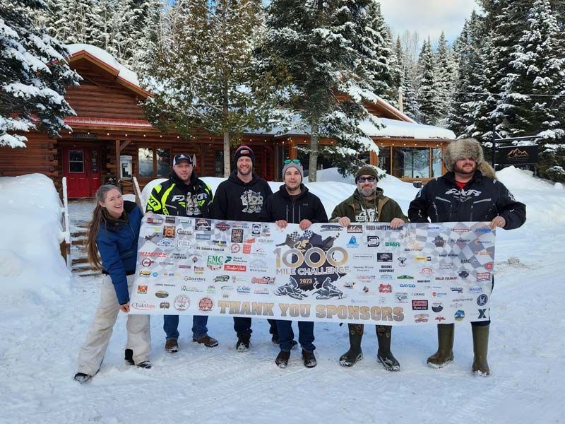 a group of people holding a banner that says 1000 mile challenge