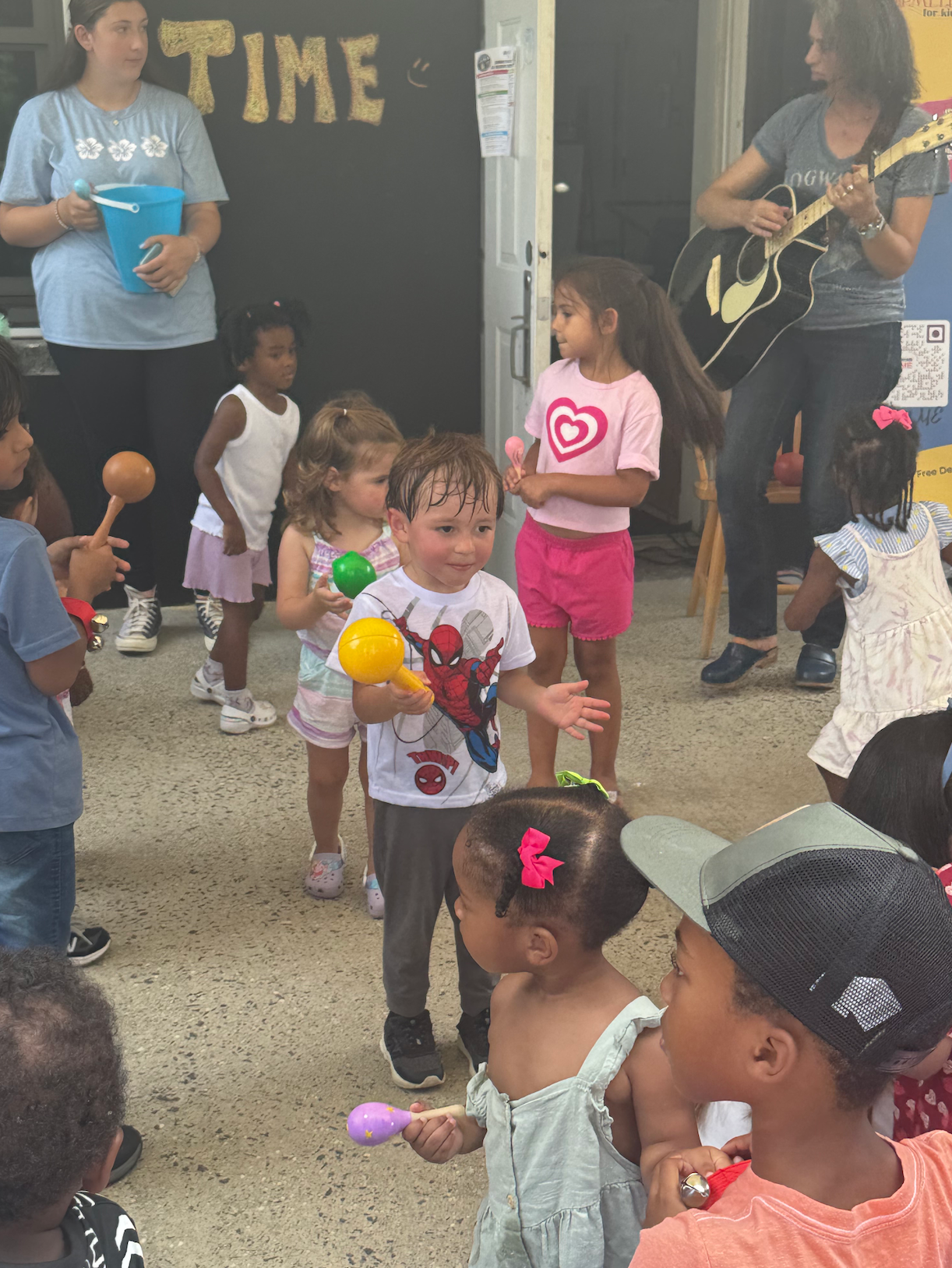 A group of children are standing in front of a sign that says time