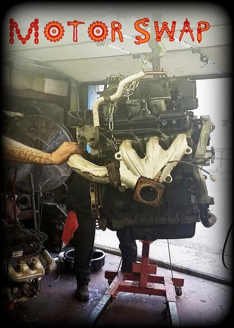 Mechanic working on an engine mounted on a stand, possibly a motor swap. 