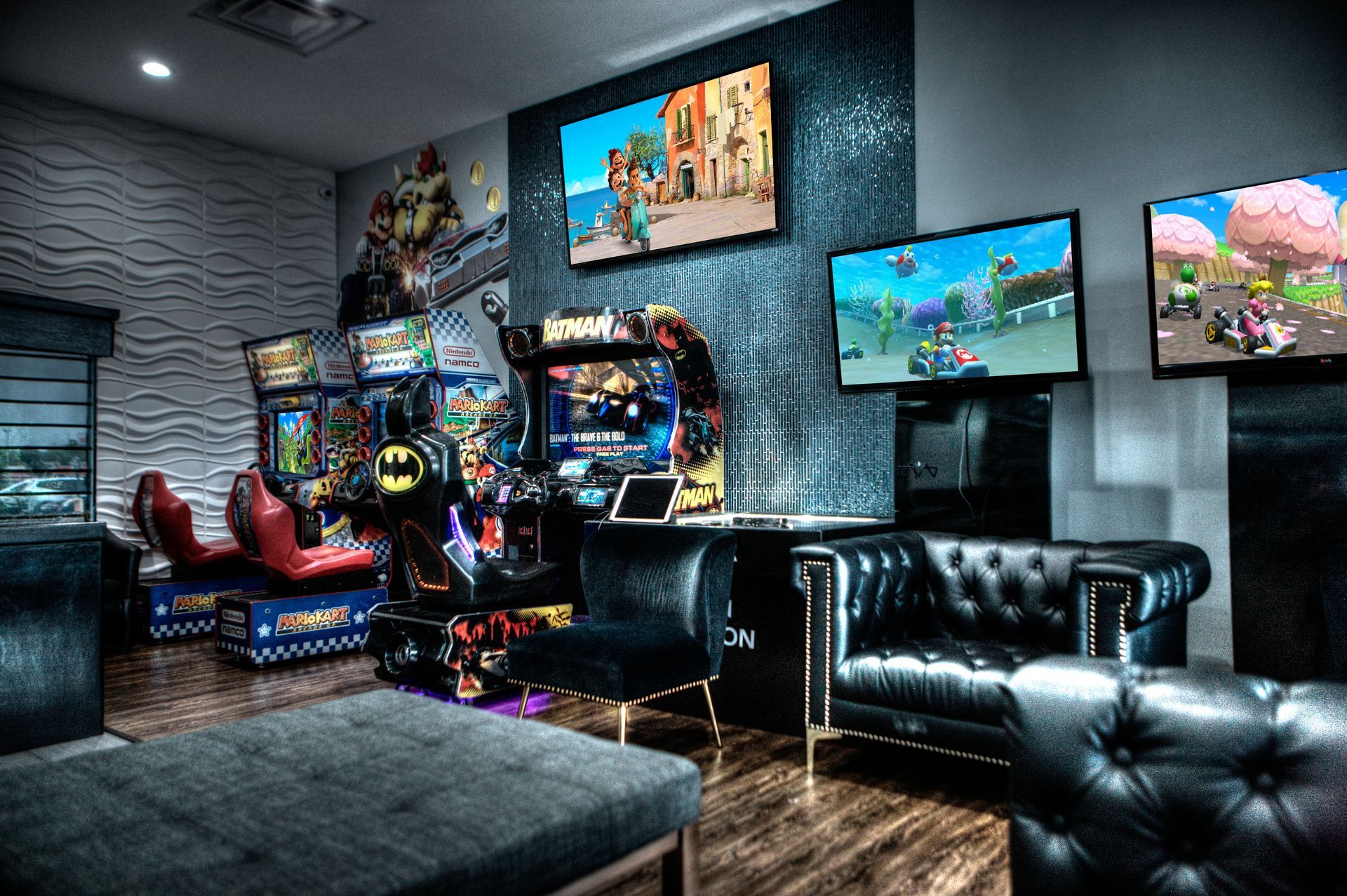 Luna-Dental-Dallas- Game room with arcade games, multiple TVs showing games, and black leather seating.