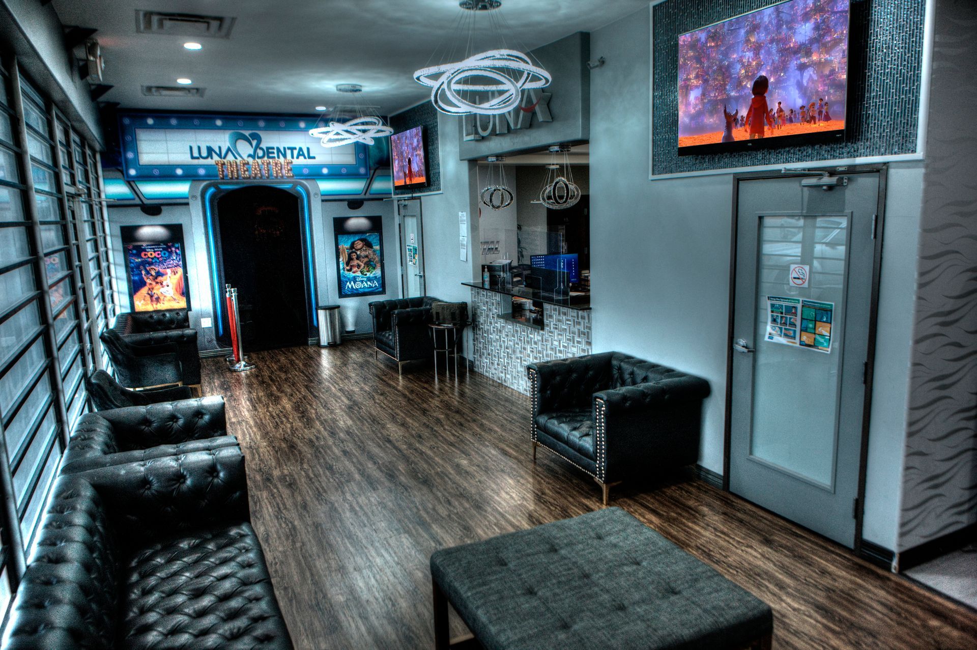 Luna-Dental-Dallas- A themed waiting room with theater posters, plush seating, and a glowing UFO light fixture.