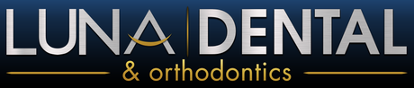 Luna-Dental-Dallas- Logo for Luna Dental & Orthodontics. Silver text on a dark blue background. The words are separated by a golden crescent.