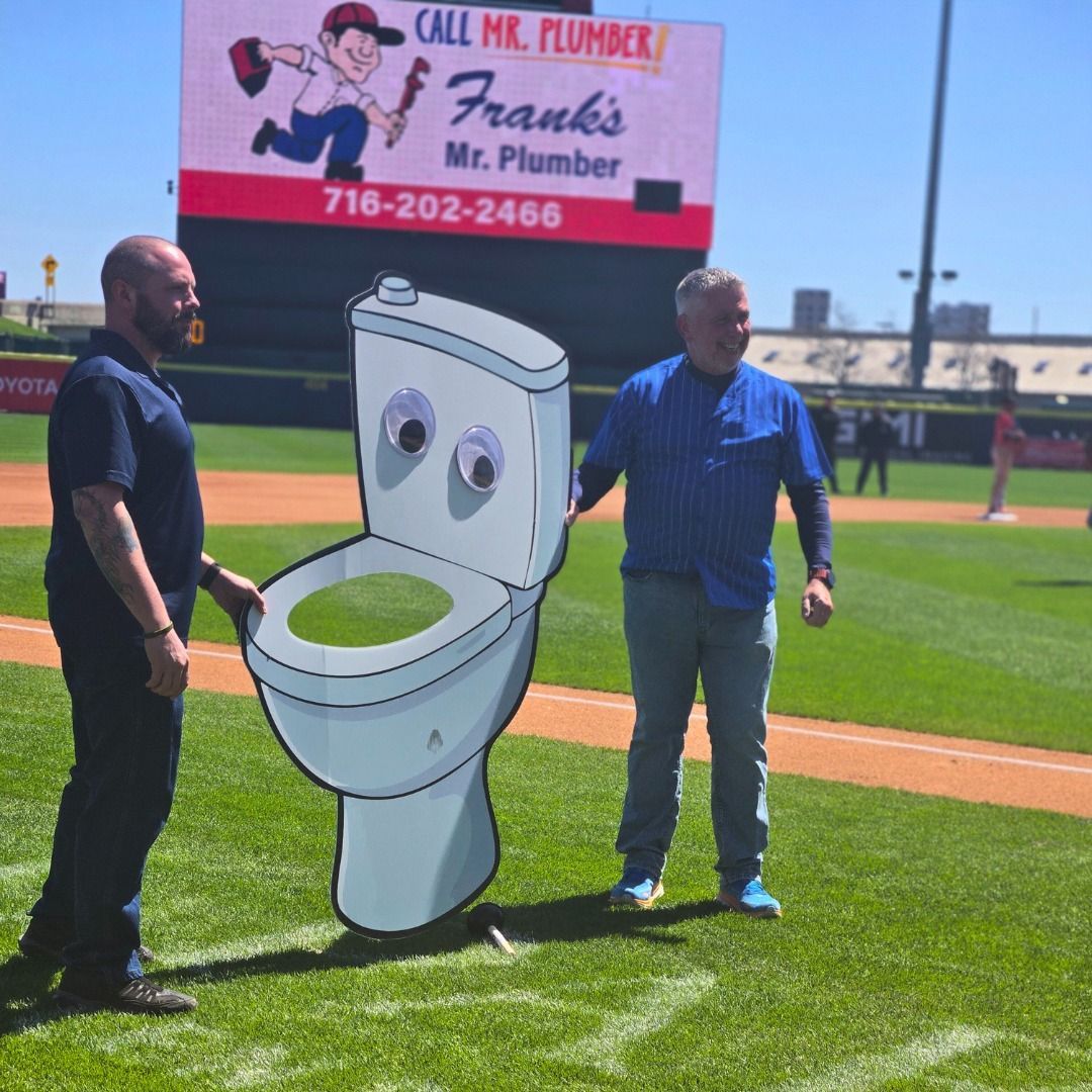 two-men-standing-on-baseball-field-holding-cutout