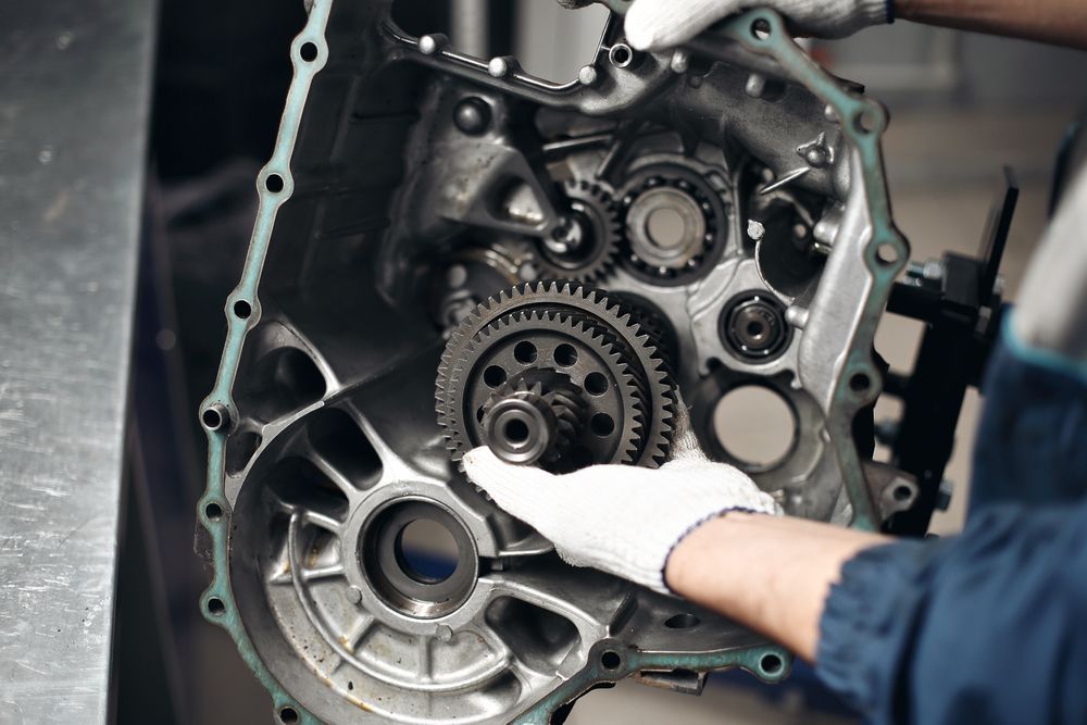 A Person is Working on a Motorcycle Engine in a Garage — Auto Blue Service Centre In Bungalow, QLD