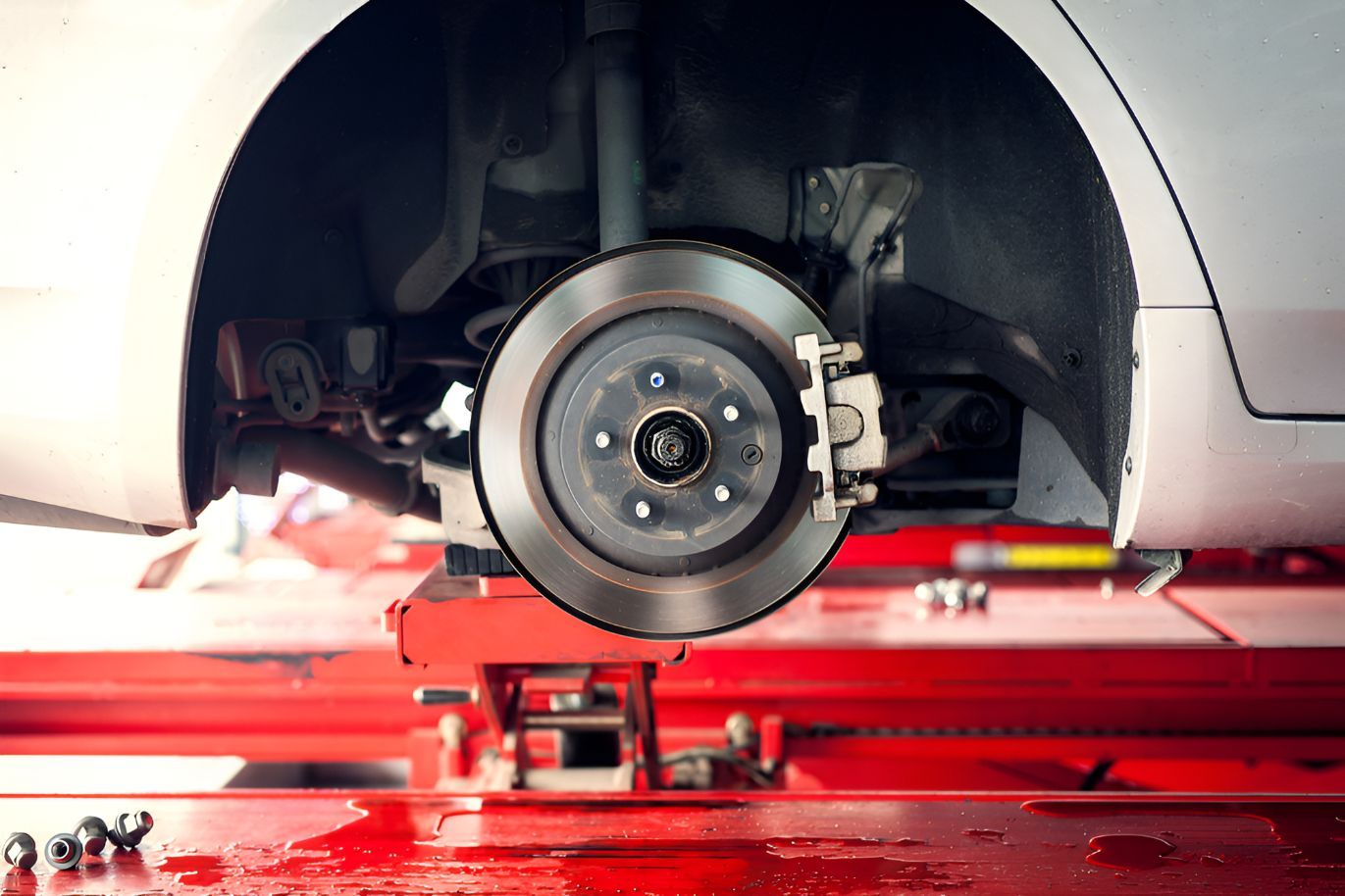 A Car is Sitting on a Red Lift in a Garage — Auto Blue Service Centre In Bungalow, QLD