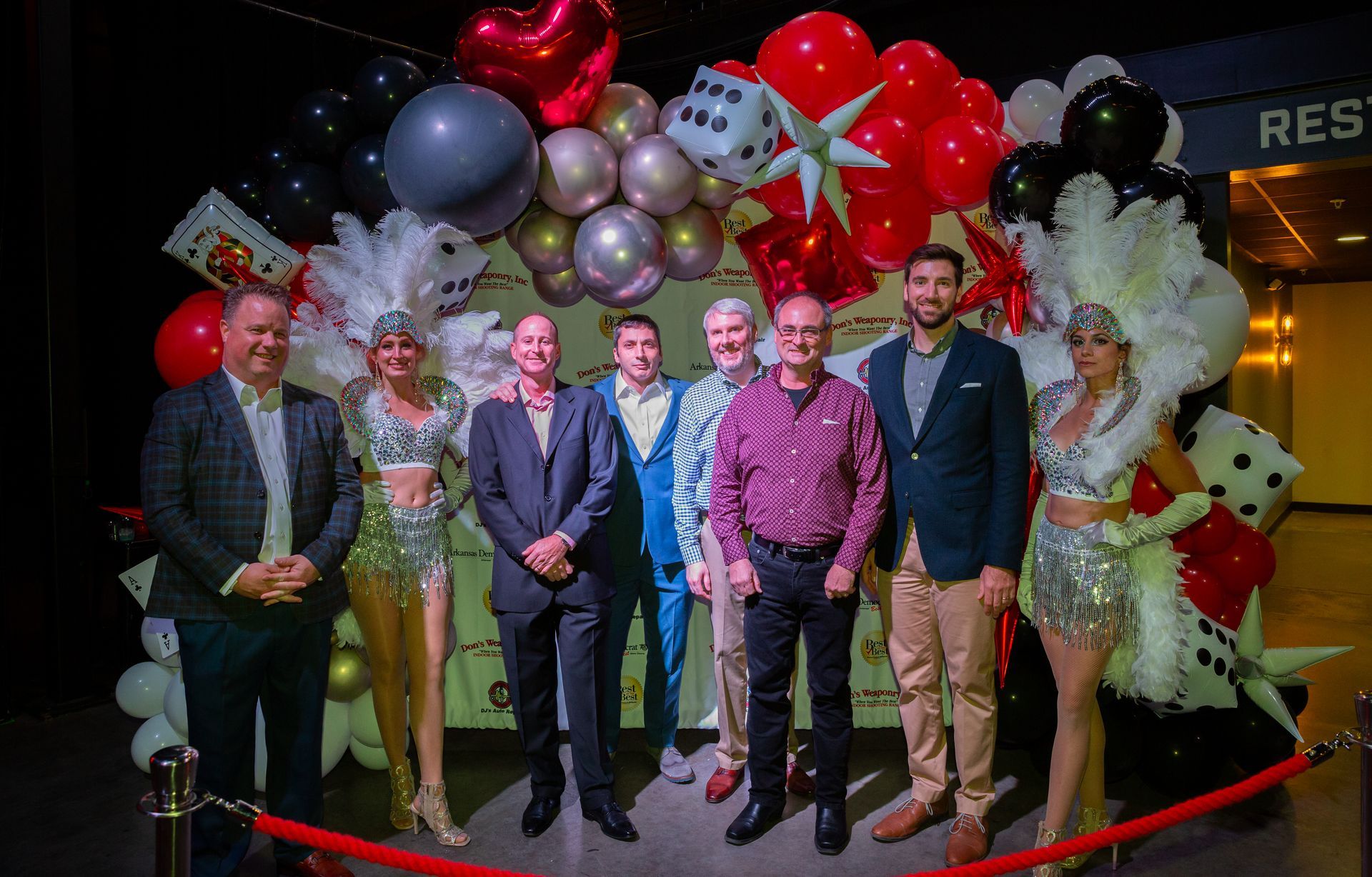 A group of people standing next to each other in front of balloons.