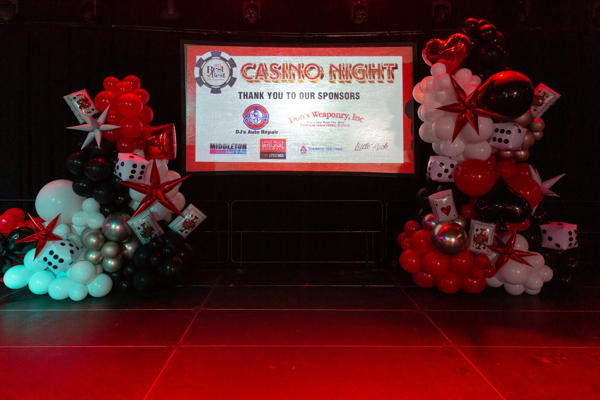 A stage with balloons and a sign that says casino night