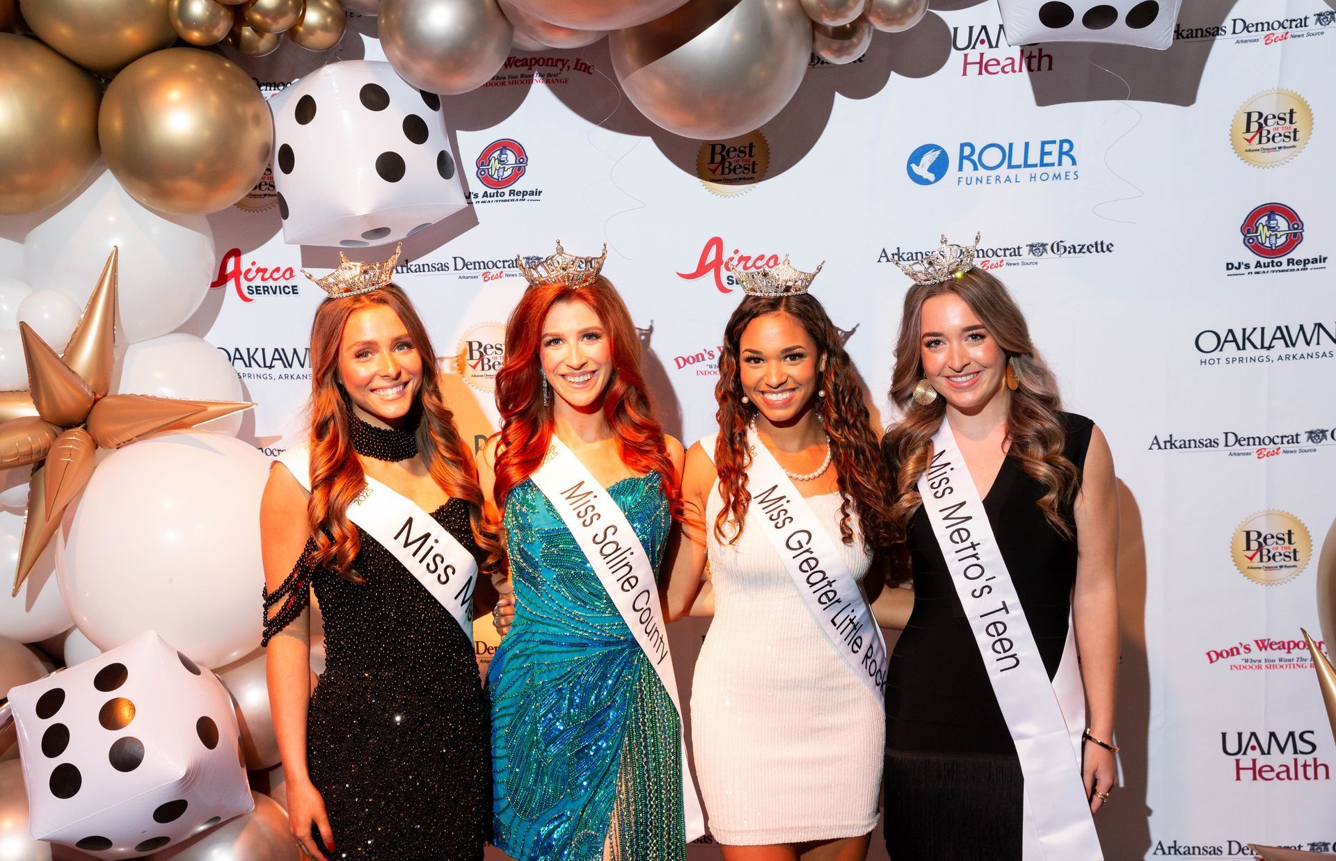 A group of women are posing for a picture in front of balloons and dice.