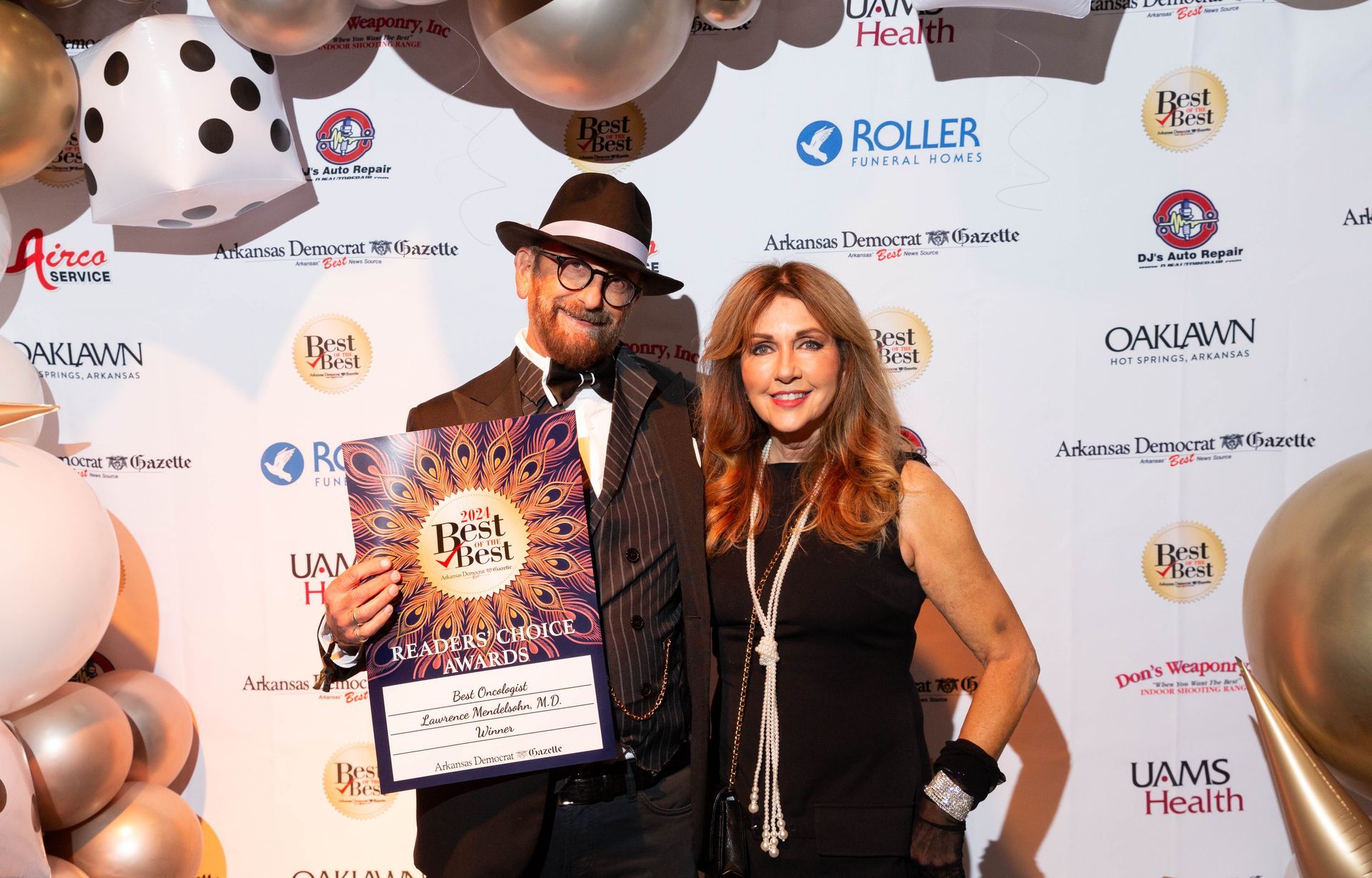 A man and a woman are standing next to each other on a red carpet.