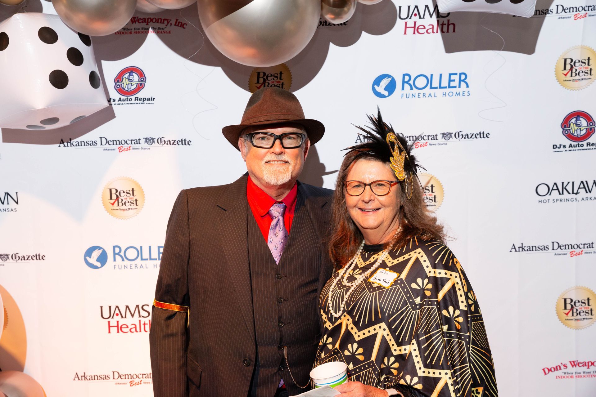 A man and a woman are posing for a picture on a red carpet.