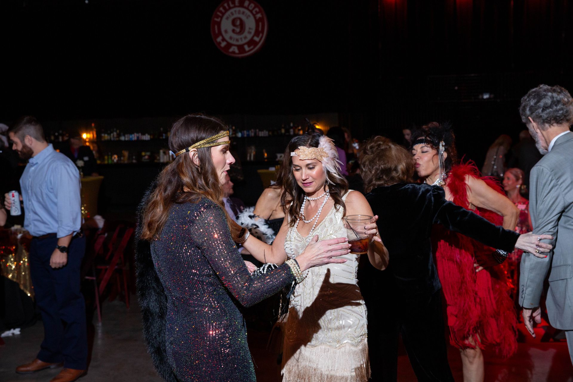 A group of people are dancing at a party in a dark room.