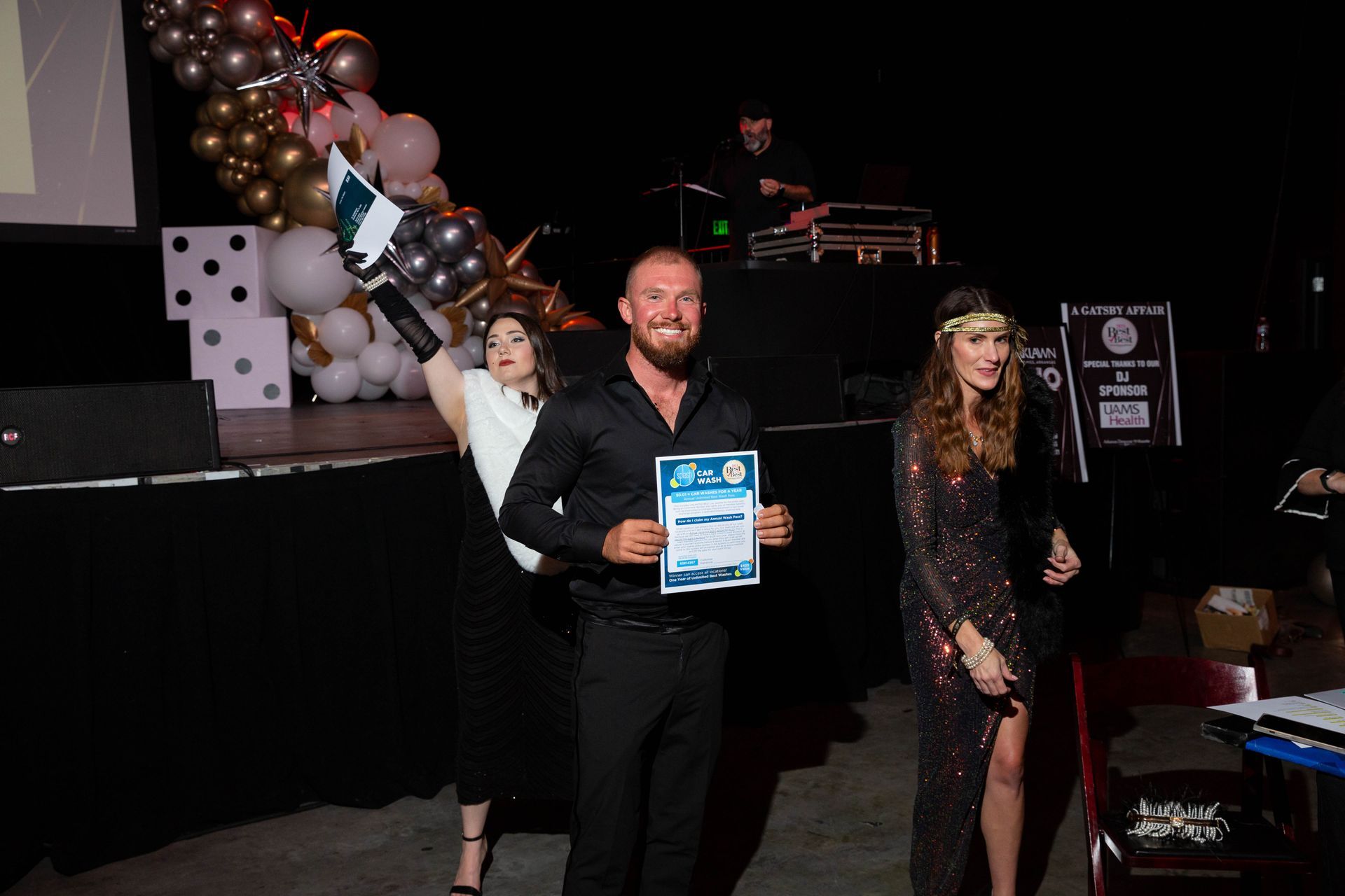 A man is standing on a stage holding a certificate.
