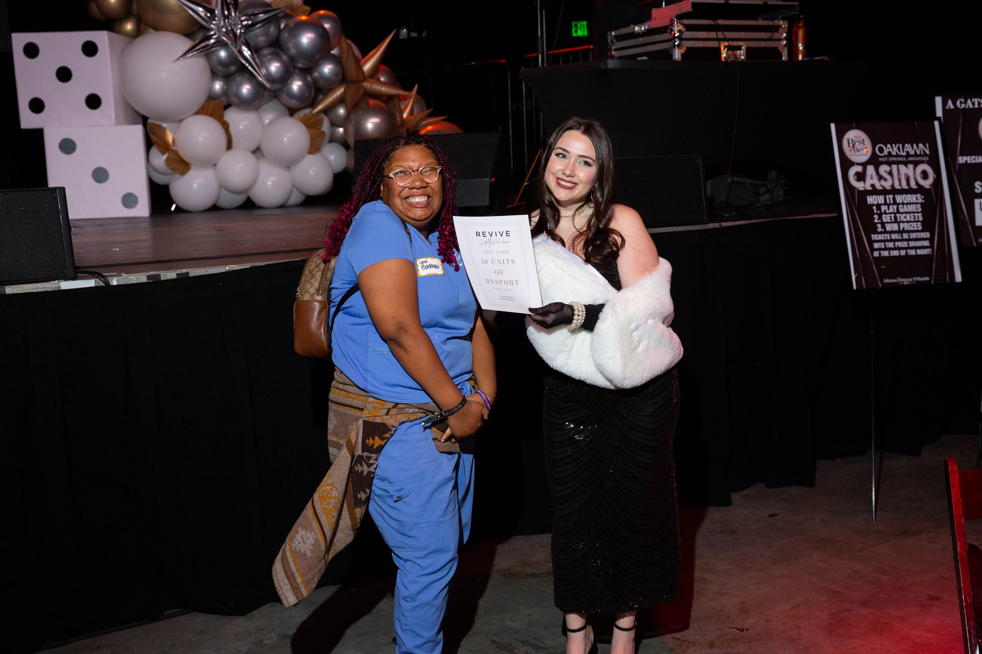 Two women are standing next to each other in a room holding a certificate.