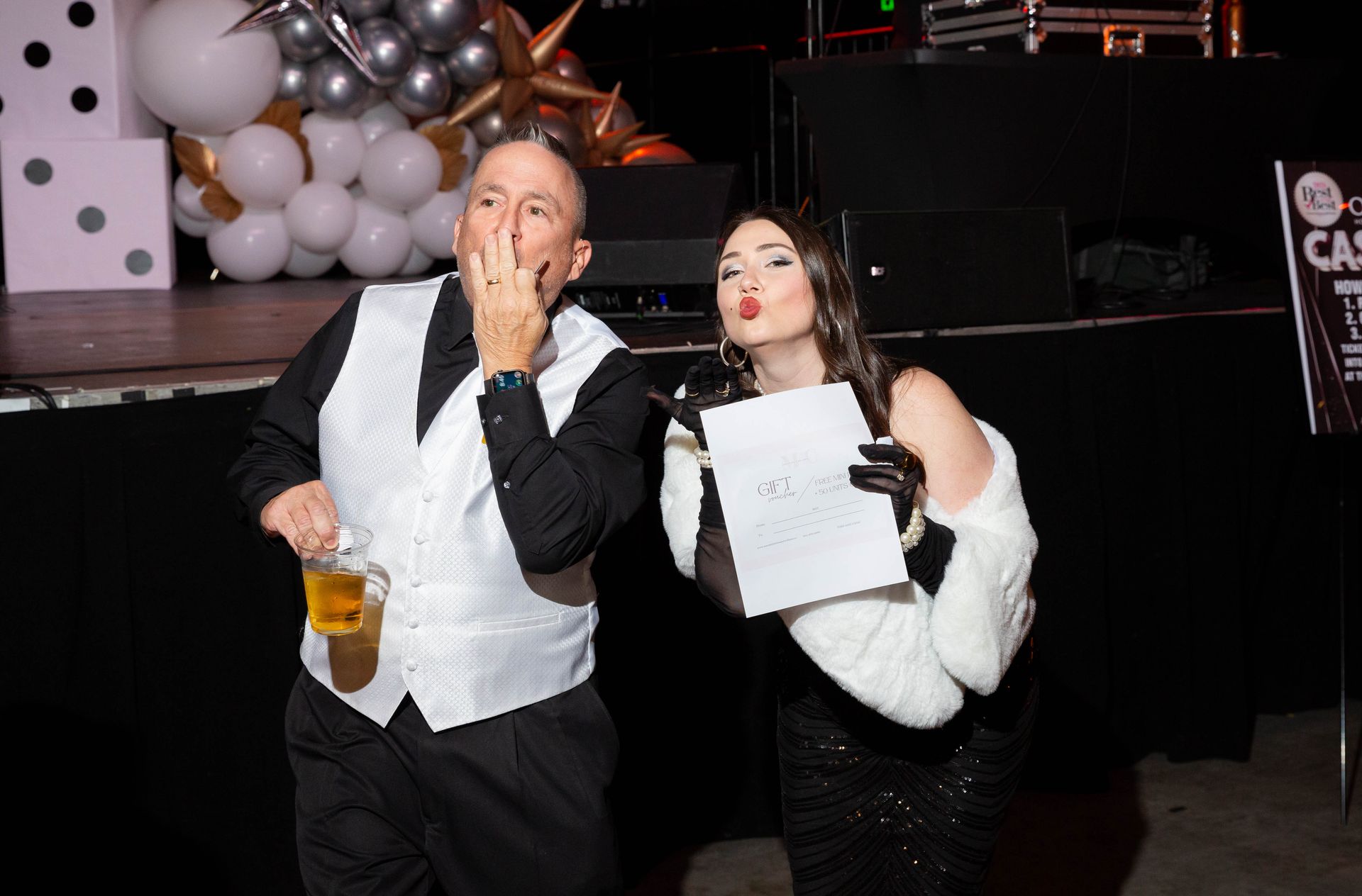 A man and a woman are standing next to each other at a party.