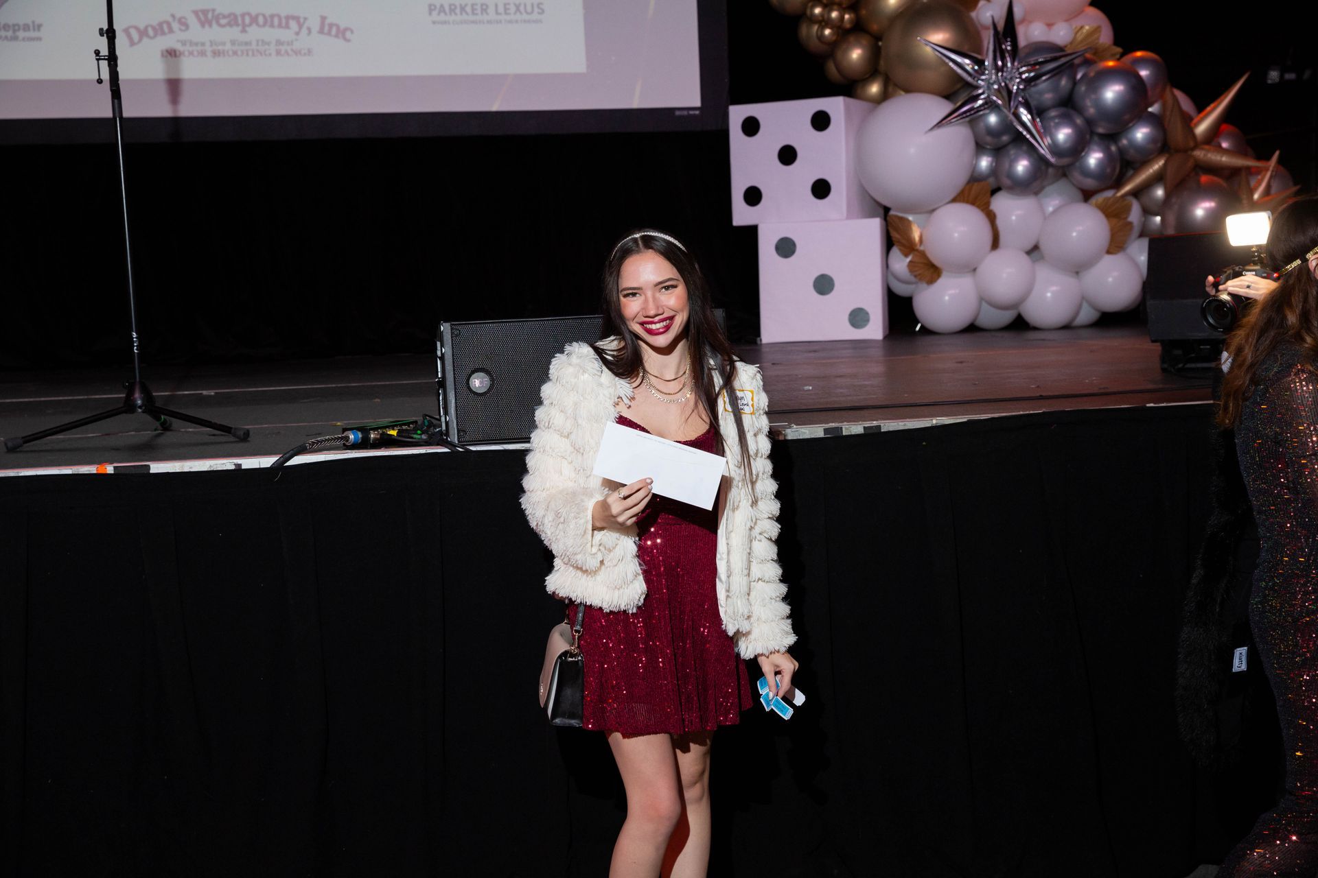 A woman is standing on a stage holding a check.