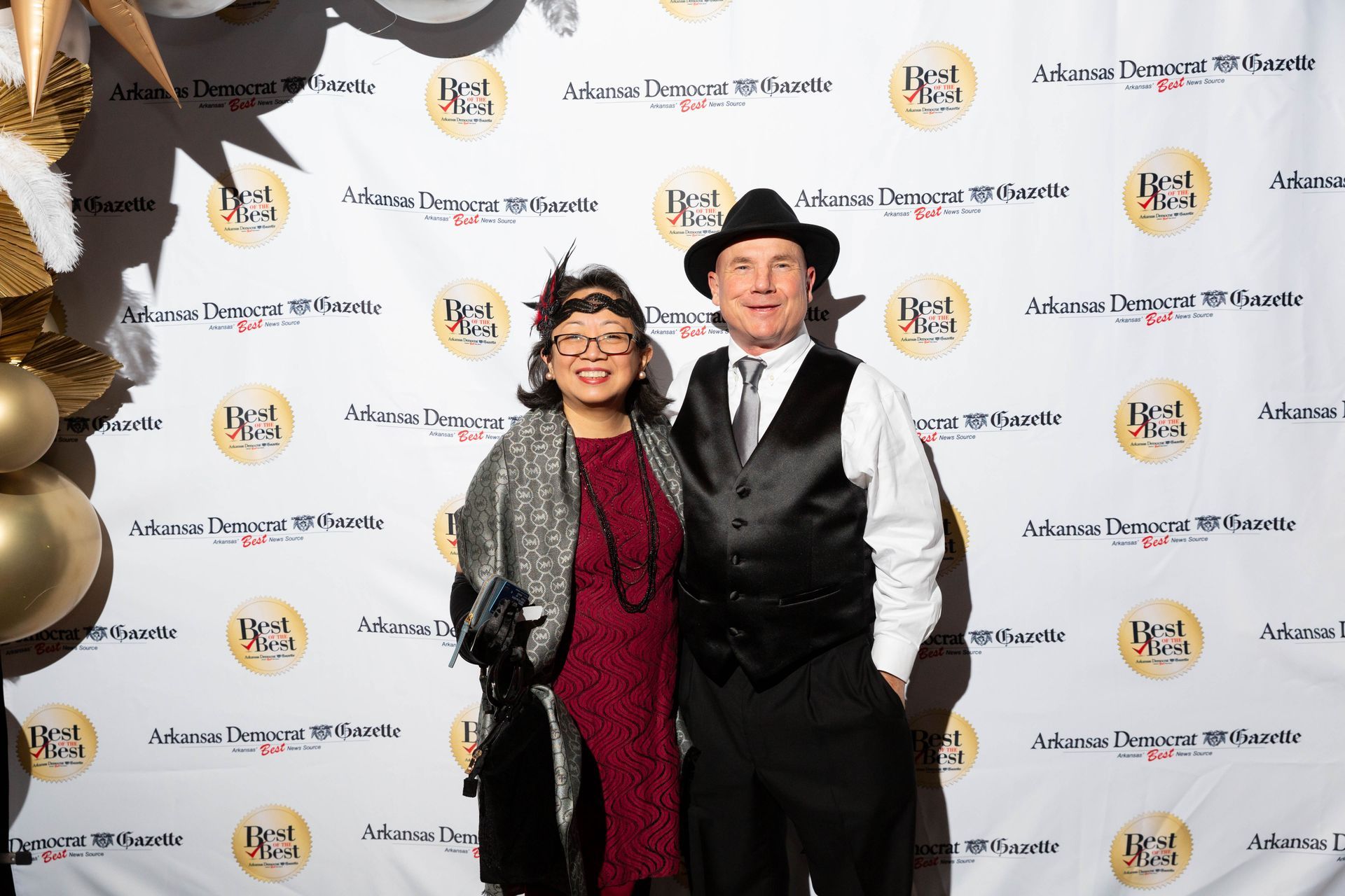 A man and a woman are posing for a picture on a red carpet.