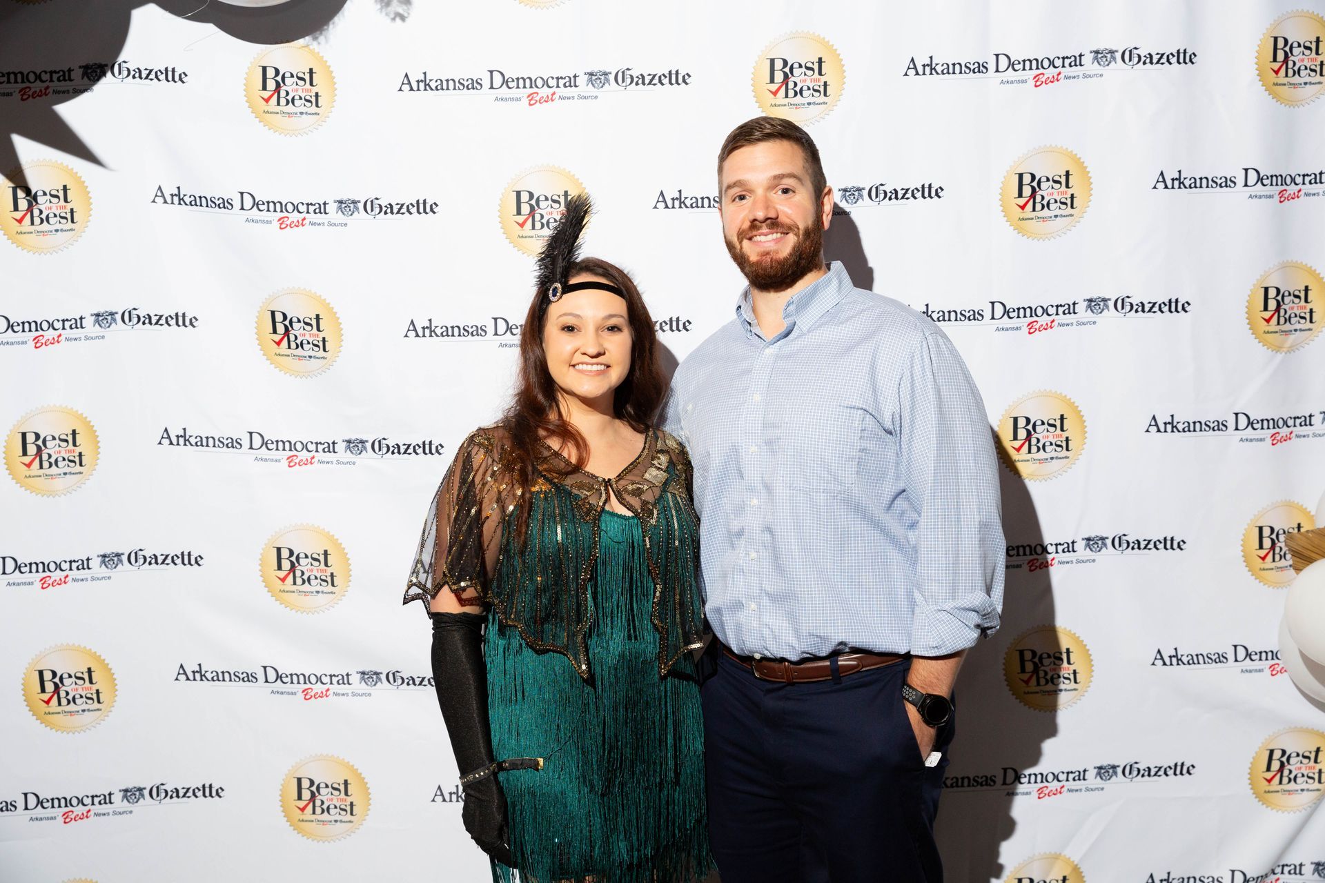 A man and a woman are posing for a picture on a red carpet.