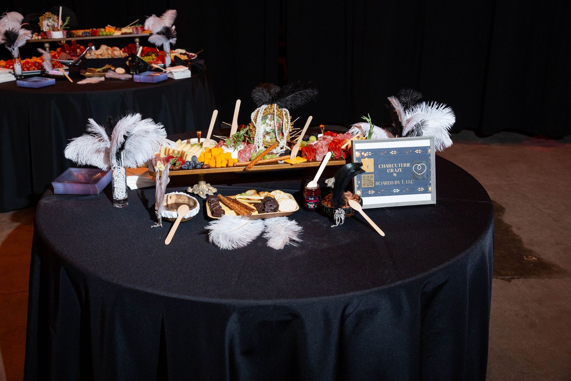 A table with a black table cloth and a tray of food on it