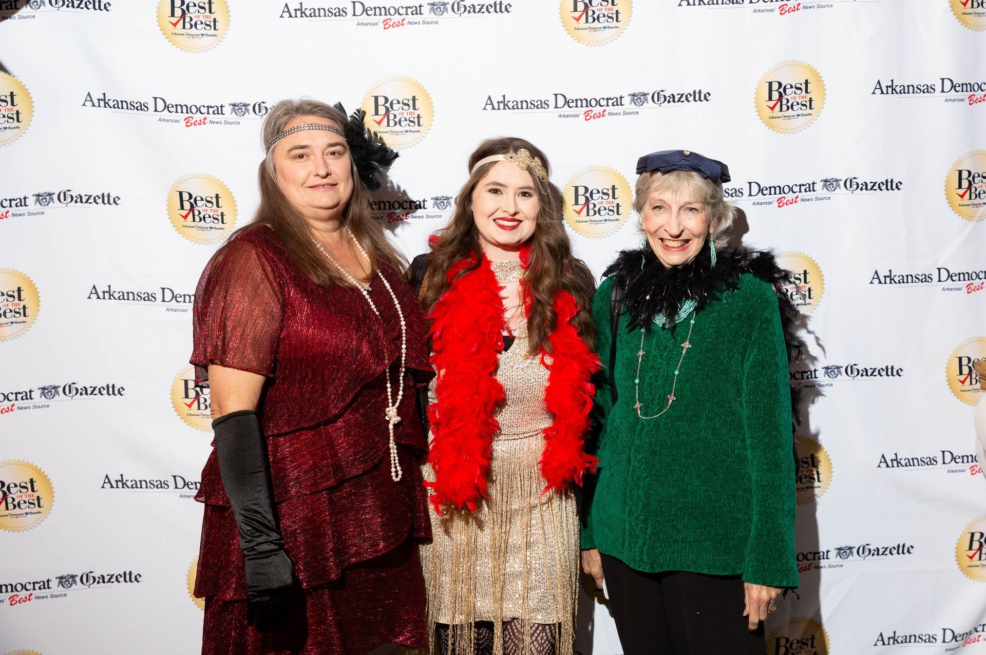 Three women dressed in flapper costumes are posing for a picture.