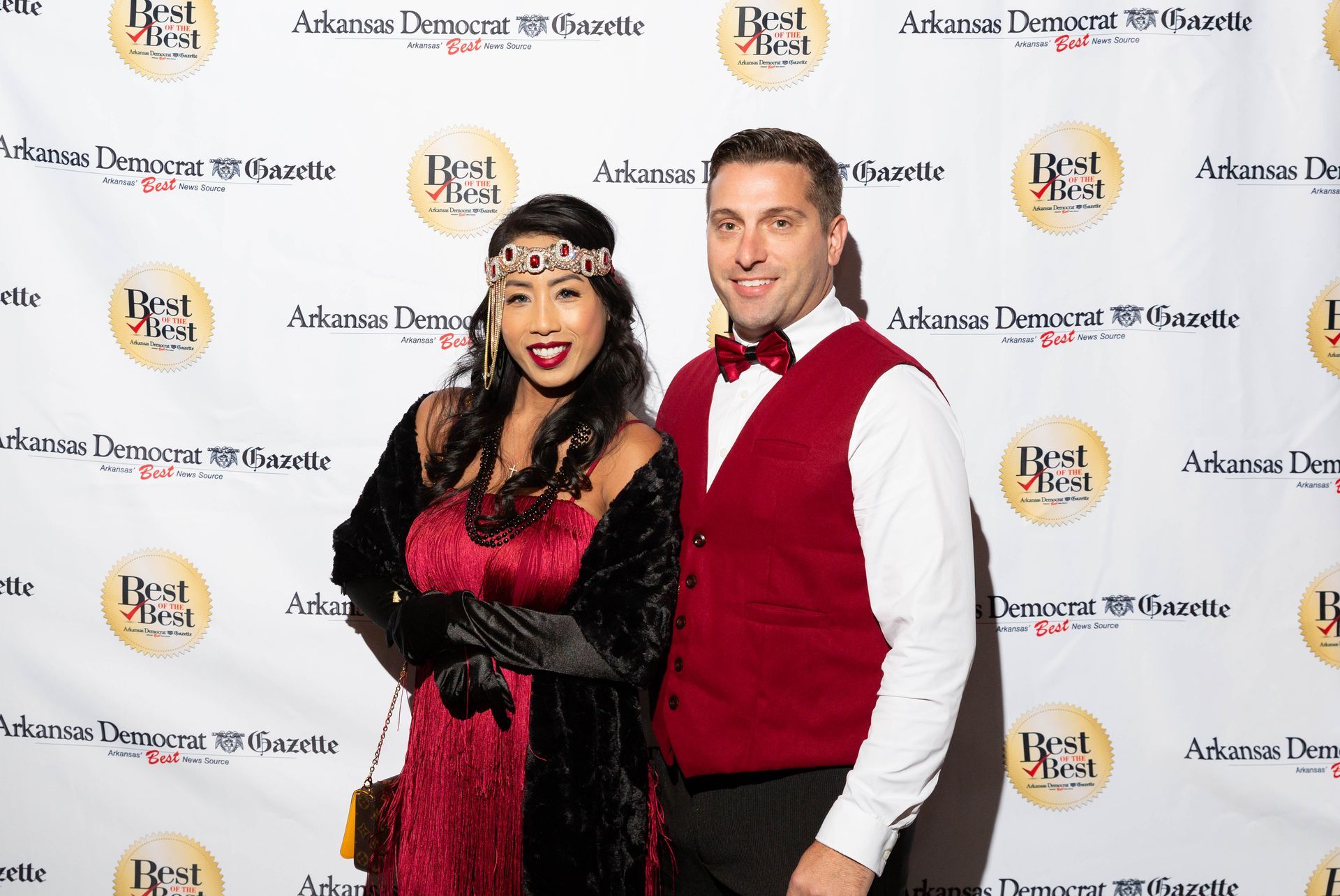 A man and a woman are posing for a picture on a red carpet.