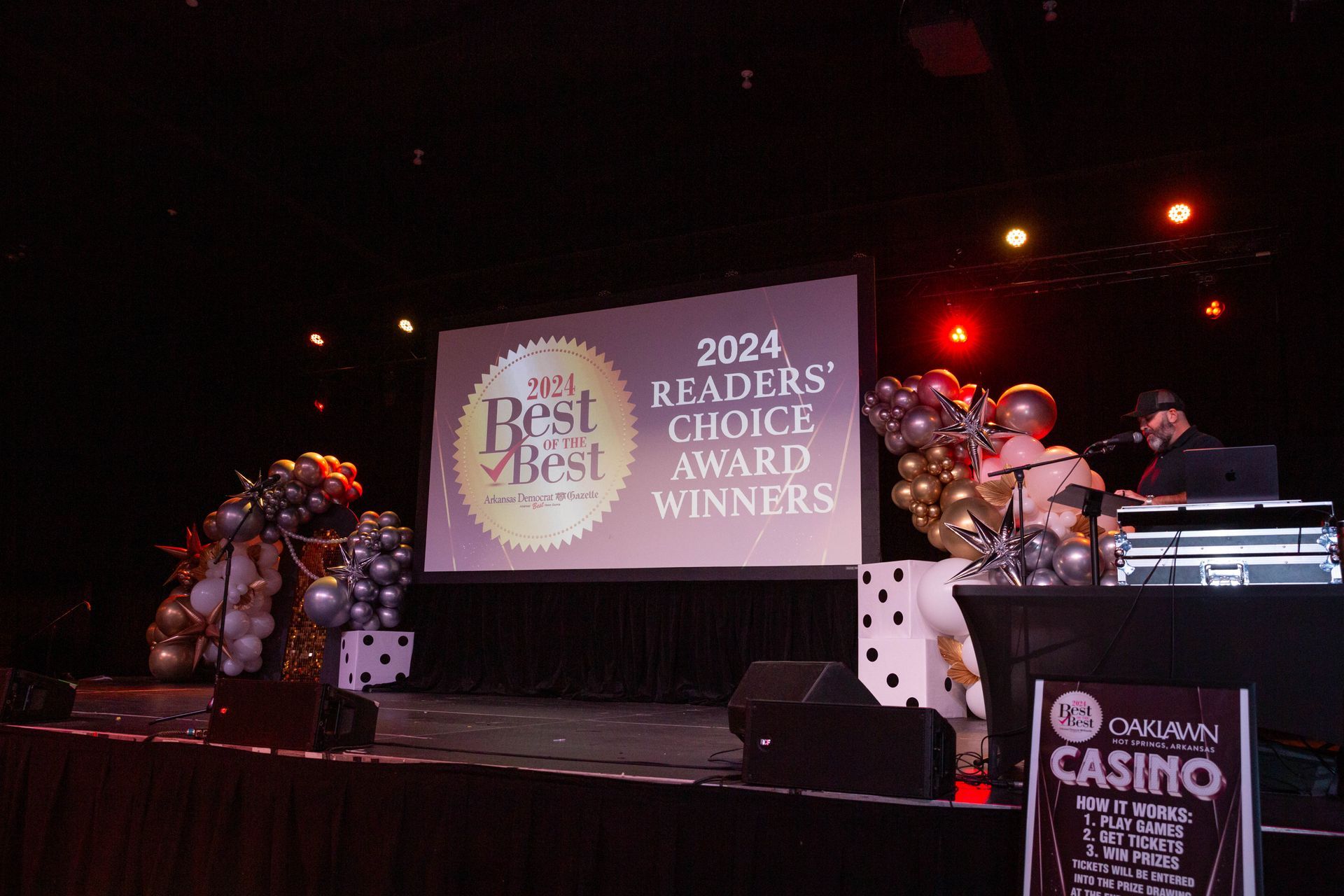 A man is standing on a stage in front of a large screen that says `` readers choice award winners ''.