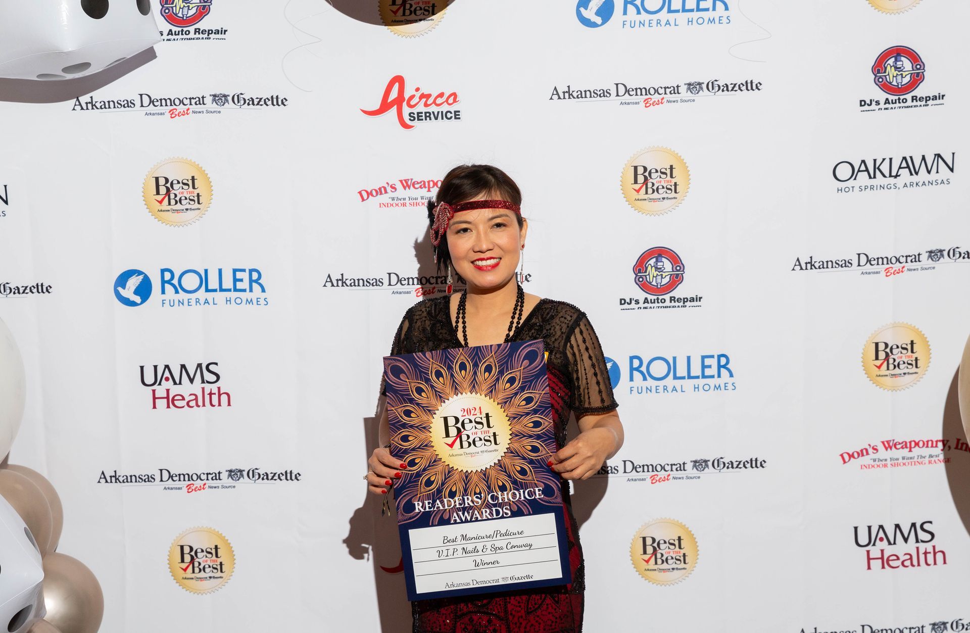 A woman is standing in front of a wall holding a sign.
