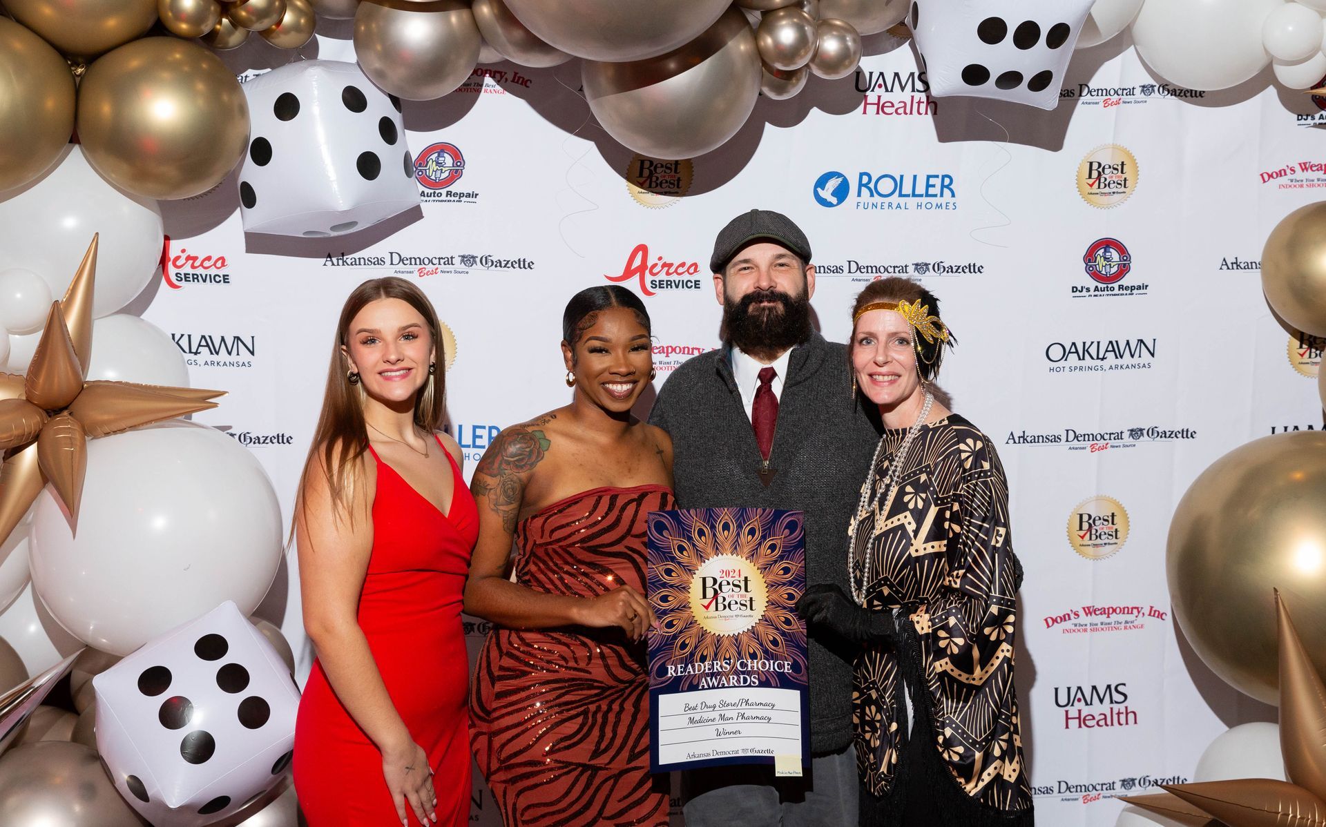 A group of people are posing for a picture in front of balloons and dice.