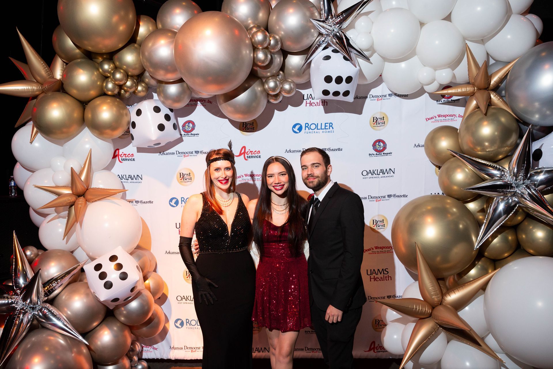 A group of people standing in front of a wall of balloons.