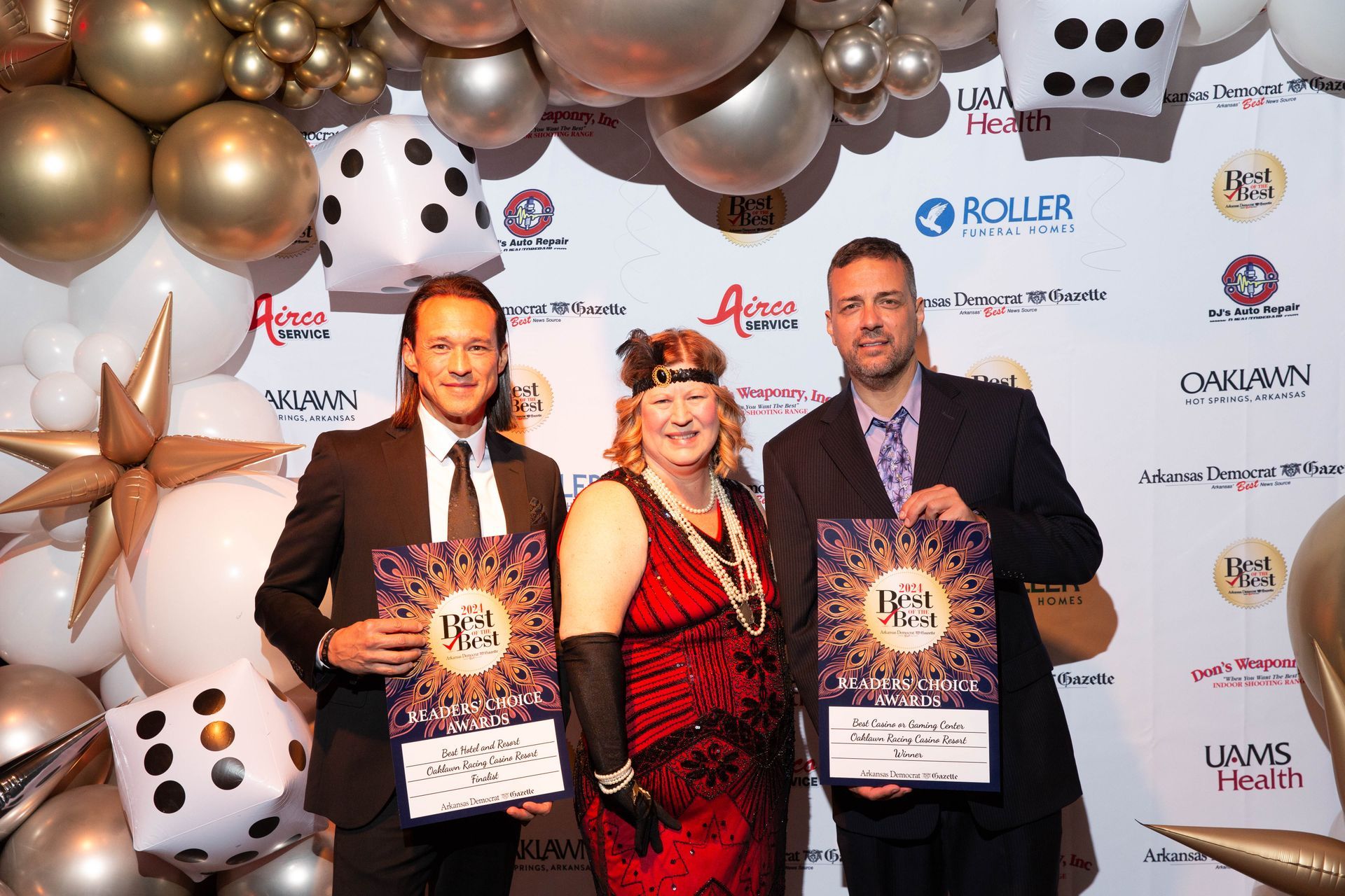 A group of people standing next to each other on a red carpet holding awards.