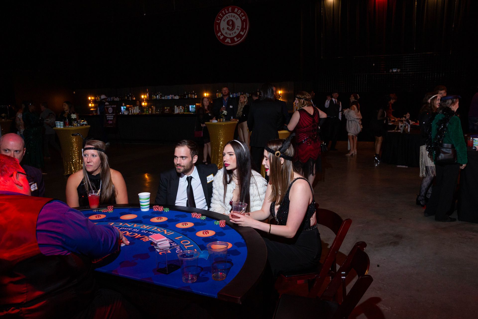 A group of people are sitting at a table playing roulette.