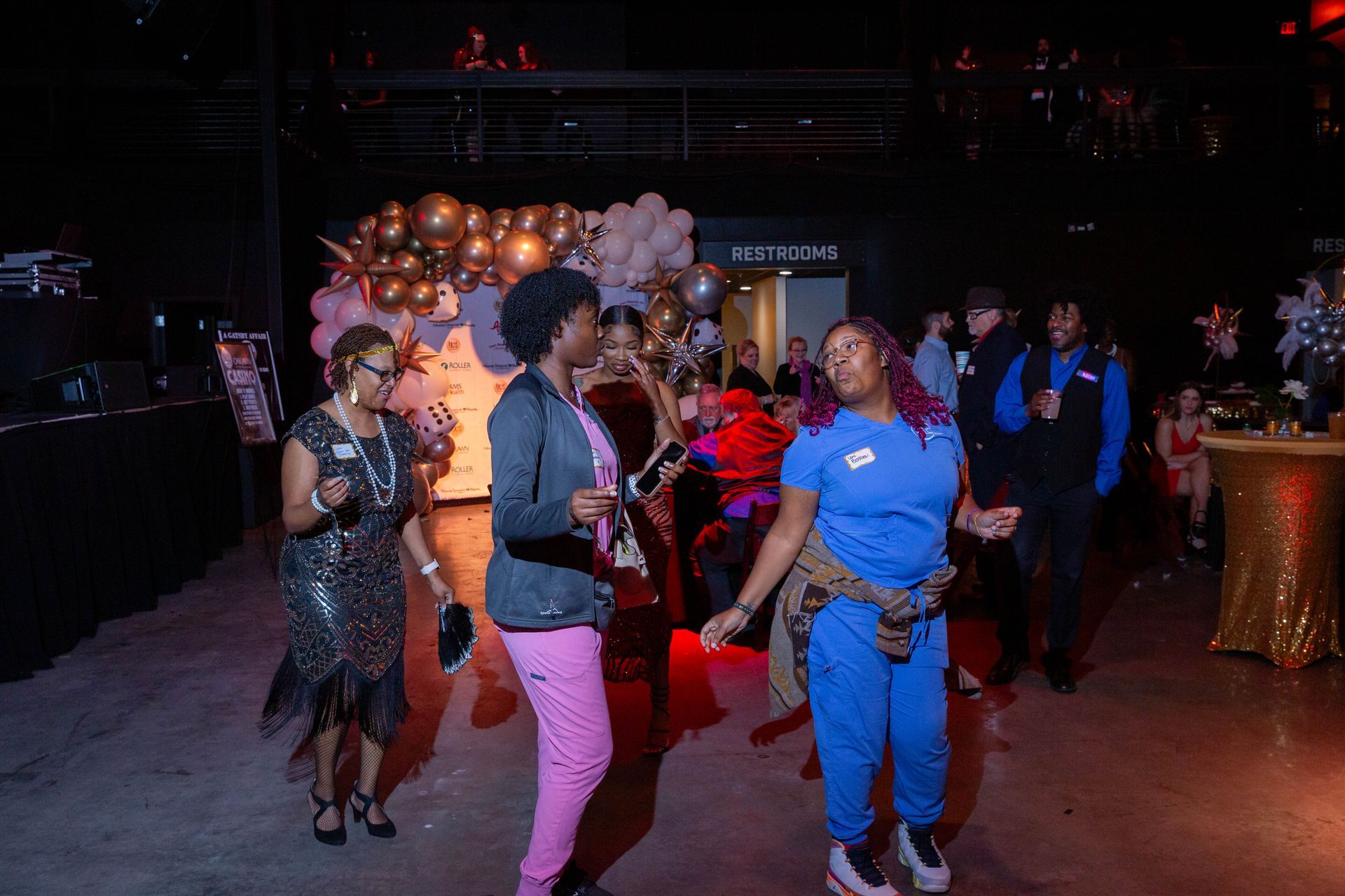 A group of women are dancing at a party in a dark room.