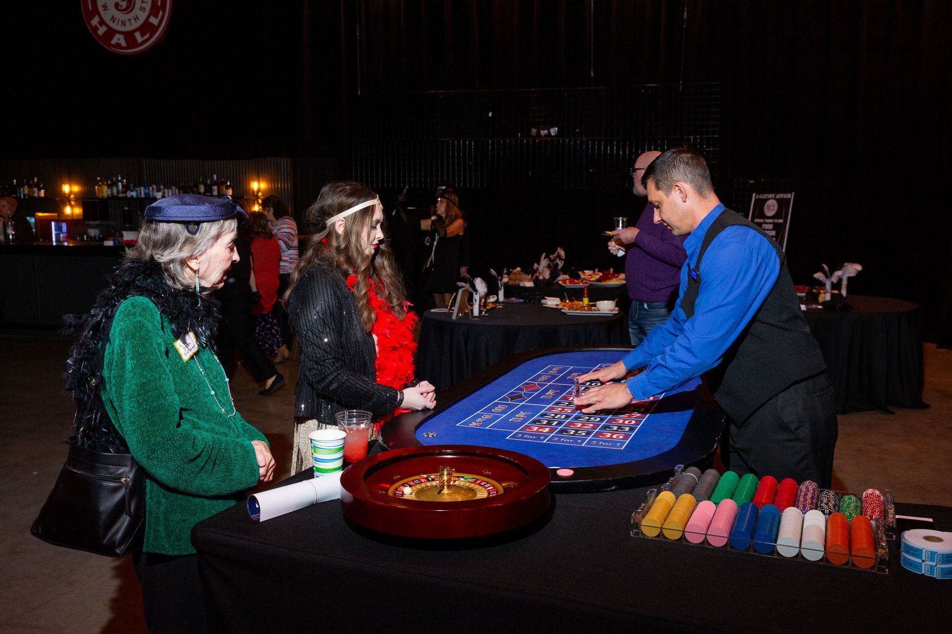 A man is playing roulette with a group of people at a table.